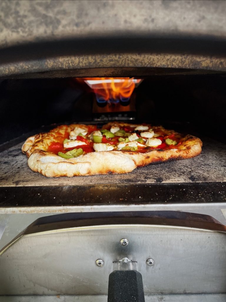 A Black Catter sent us this photo of a pizza in his Ooni pizza oven that is laquered with tomato sauce he made last autumn with tomatoes from one of our u-pick events.